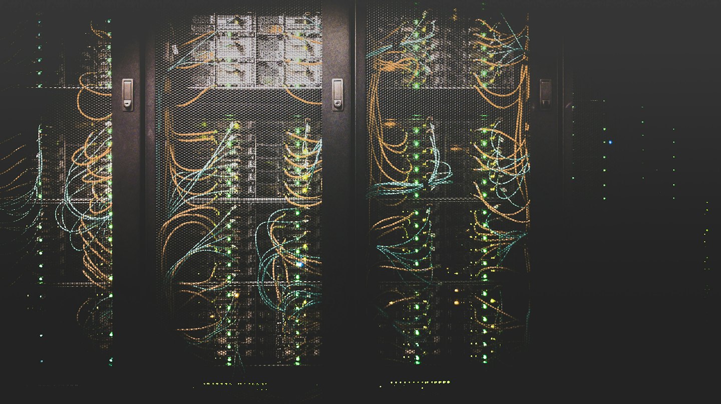 Server racks with blinking green lights and colorful cables.